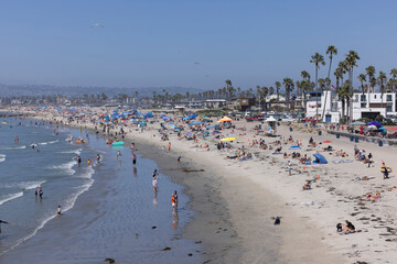 San Diego, California, USA - August 27, 2023: People enjoy the sand and surf of Ocean Beach on a hot day.