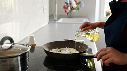 Woman Pouring Oil Into Pan With Onions