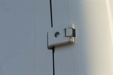 This image shows a robust metal latch firmly attached to a clean white panel, illustrating a vital...