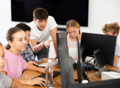 Portrait of female schoolgirl at computers in shool computer class