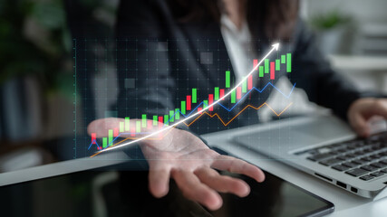 Business professional conducting financial analysis with digital data visualization in modern office. Laptop displays stock market trends and growth indicators. Impute