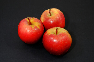 Fresh red apples together on black background close up view