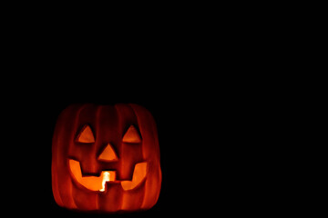 Illuminated Halloween pumpkin on a black background with space for advertising. Ideal for Halloween on October 31st.