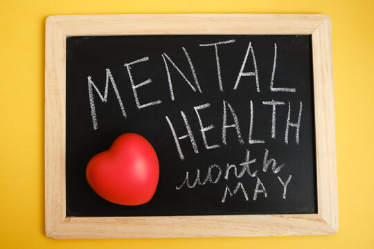 red heart and chalk writing on black board mental health month may, emotional health concept