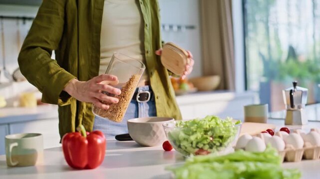 Woman hands pouring granola adding milk at cuisine closeup. Housewife cooking