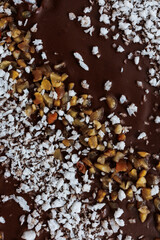 Macro photo of chocolate texture with coconut and nut pieces