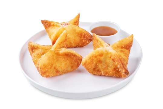 Crab rangoon with sauce in a plate on a white isolated background