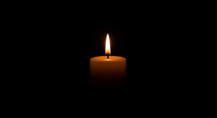 Glowing Candle Flame Illuminating Darkness Center Isolated on Black Background With Warm Light