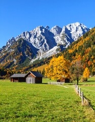 Autumnal mountain valley with wooden cabins