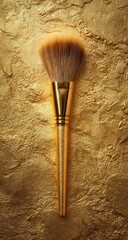 Gold makeup brush on gold textured surface