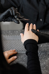 Fototapeta premium Professional manicure session for young caucasian female, black uniform