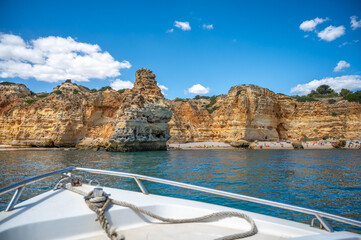 Beautiful rock formations cliffs caves geology grottos of the Portugal southern Algarve coast with beaches people and kayaks near Benagil seen from water calm ocean copy space travel nature background