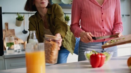 Active girlfriends cooking together in kitchen closeup. Couple making breakfast - Powered by Adobe
