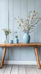 Beautiful floral arrangement on a wooden table with blue vases against a light blue wall