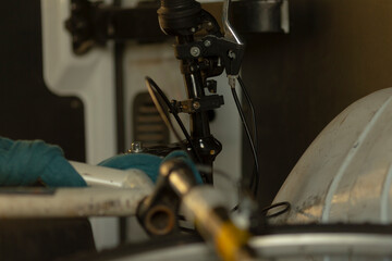 A closeup shot captures a skilled bicycle mechanic who is meticulously adjusting the brake components of a bike within a wellorganized workshop environment, surrounded by various tools