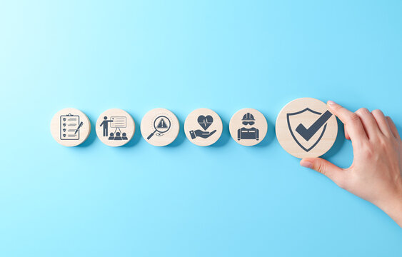 Work safety and compliance concept. Wooden blocks safety-related icons, including compliance, health, inspection, training, protection, regulatory, workplace safety, and risk management. Safety first,