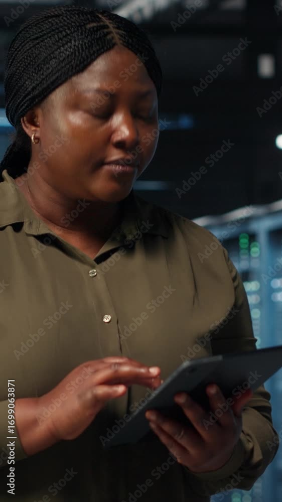 Poster vertical video data center employee using tablet to manage software updates for system stability. af