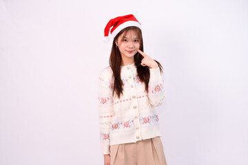 smiling pretty woman in santa hat with festive sweater celebrating the holiday season in christmas concept white studio background