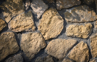Close-up of rustic natural stone wall texture. Perfect for architectural design, decorative background, construction and creative projects.