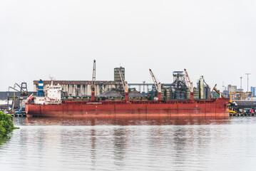 Bulk carrier ship with cargo cranes docked at the port of Buenaventura, Colombia. 