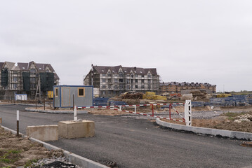 Obraz premium The ongoing development of modern buildings at the construction site is a vital task in progress. A construction site showcasing the ongoing development of modern residential buildings and facilities