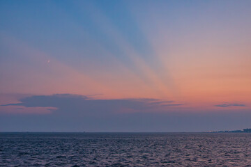 光芒のびる夕焼けと海