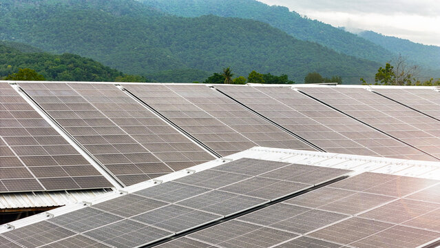 A commercial-scale photovoltaic (PV) solar array installed on an industrial building's roof. This renewable energy system feeds clean electricity directly into the power grid.
