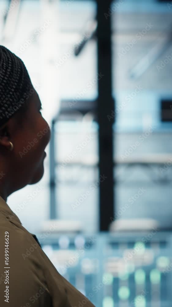 Poster vertical video technician in data center overseeing large scale it gear to maintain seamless operati