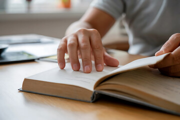 Person reading an open book with fingers on pages and turning a page hands turning page