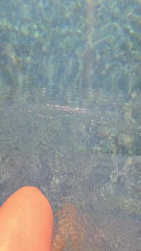 Close up woman's legs lgo into the water in pool. Driving plate, pov, first person view. Vertical