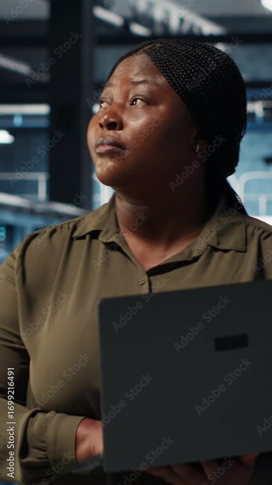 Poster vertical video data center system administrator uses laptop to develop disaster recovery plans, mini