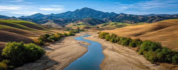 Dried lake and river in hot summer season concept. Scenic panorama of a river winding through golden hills and mountains.
