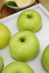 Fresh Green Apples in White Foam Box with Shallow Depth of Field