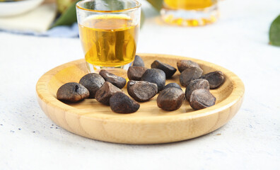 Camellia Tea Seeds with Golden Oil on Wooden Plate - Agricultural Harvest and Natural Oil Production