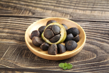 Camellia Tea Seeds in Wooden Bowl on Rustic Wood Background - Natural Organic Agricultural Product