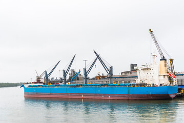 Bulk carrier ship with cargo cranes docked at the port of Buenaventura, Colombia. 