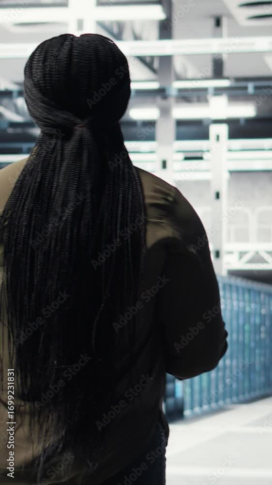 Poster vertical video woman walking through data center server rows, implementing advanced cooling and powe