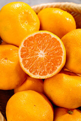 Fresh Ripe Oranges in Basket with Cut Half Showing Juicy Citrus Segments