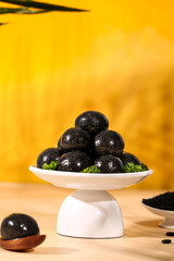 Black Sesame Balls on White Stand - Traditional Asian Sweet Treats and Healthy Snacks Closeup