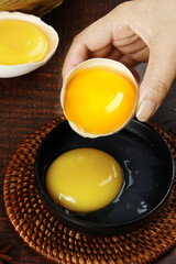 Fresh Farm Eggs with Bright Orange Yolks Being Cracked for Cooking