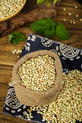 Buckwheat Grains in Burlap Sack on Wooden Base - Organic Farming and Healthy Food Concept
