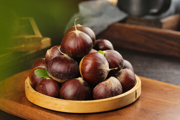 Fresh Alpine Chestnuts in Wooden Bowl on Rustic Kitchen Table