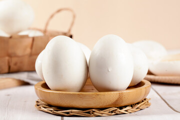 Fresh White Goose Eggs in Wooden Bowl on Rustic Farmhouse Kitchen Counter
