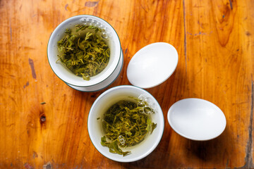 Traditional Green Tea Brewing in White Cups on Wooden Table