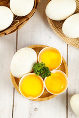 Fresh Farm Eggs with Golden Yolks in Wooden Bowls on Rustic Kitchen Table