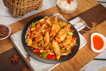 Spicy Stir-Fried Frog Legs in Cast Iron Pot - Traditional Asian Cuisine with Rice and Vegetables