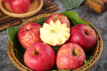 Fresh Red Apples in Wicker Basket with Star-Cut Slice on Rustic Wood Background