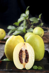 Fresh Yunnan Papaya Fruit with Cut Half Showing Orange Flesh and Seeds on Rustic Wood Background