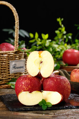 Fresh Red Apples Sliced in Half on Rustic Wooden Table with Wicker Basket