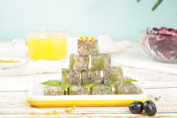 Jellied Fish Aspic Cubes with Fresh Herbs - Traditional Cold Appetizer on Yellow Plate